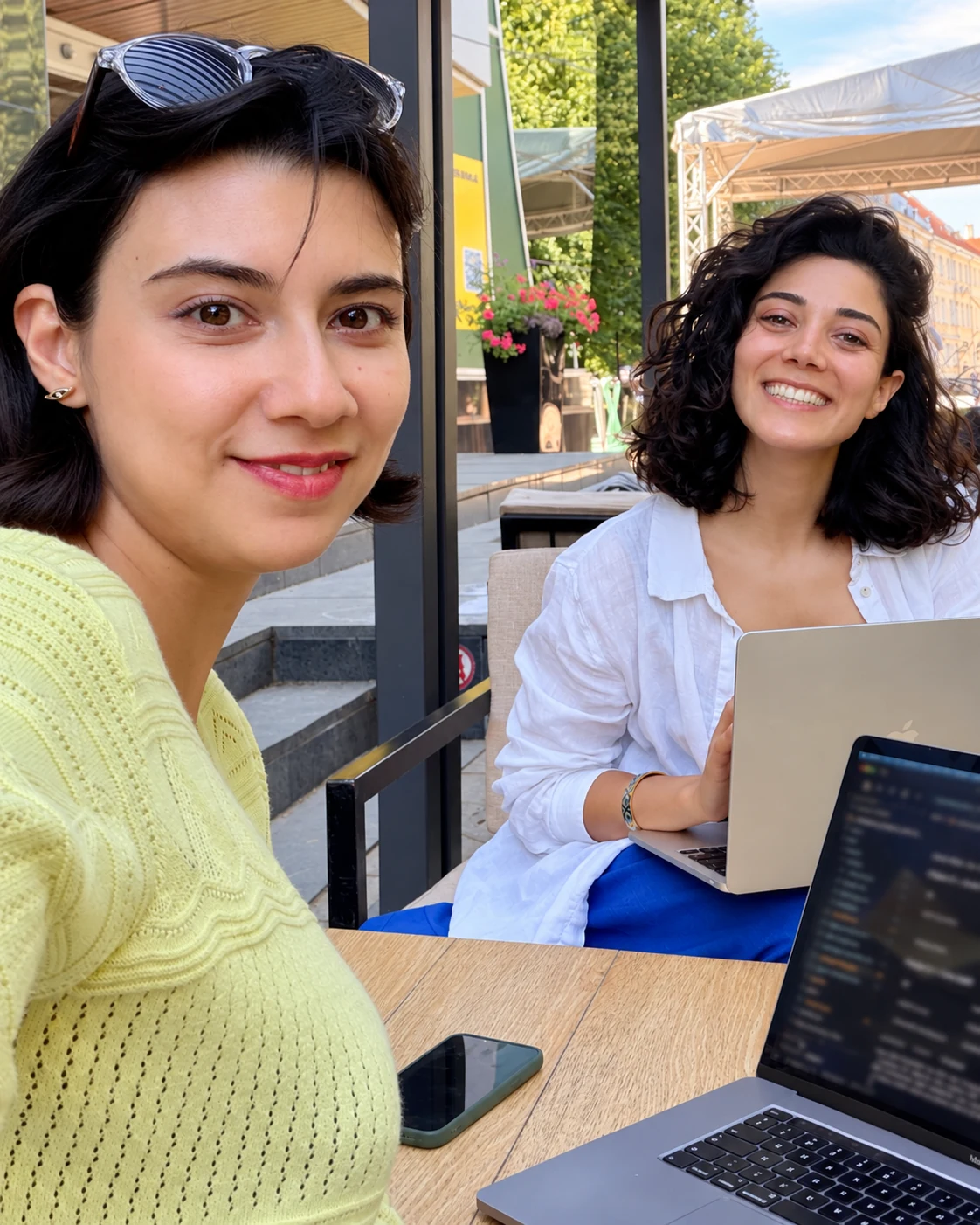 Diela’s two co-founders sharing a café table with their laptops